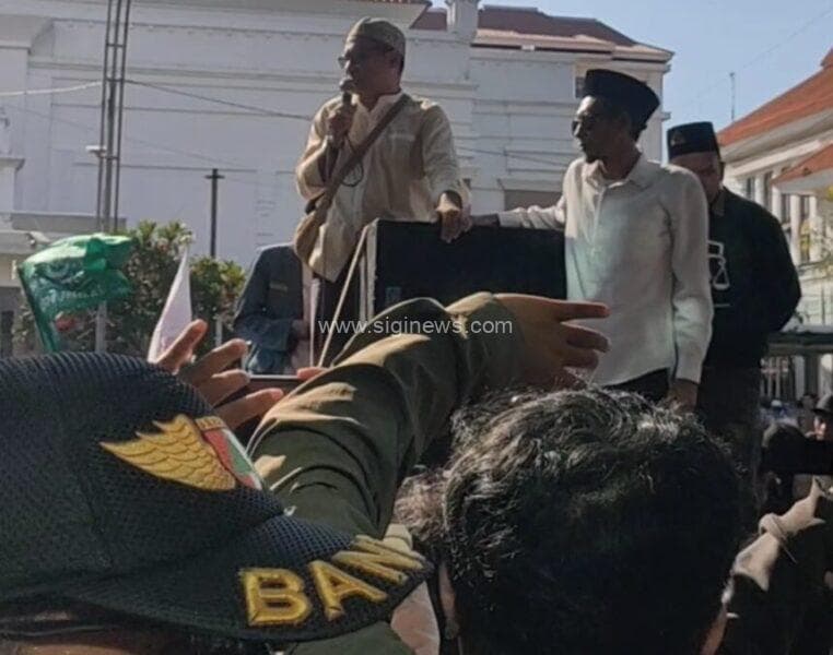 Kepala Biro Trans Media Jawa Timur Walid (memegang mic), saat menemui massa santri. (foto: jero/siginews.com)