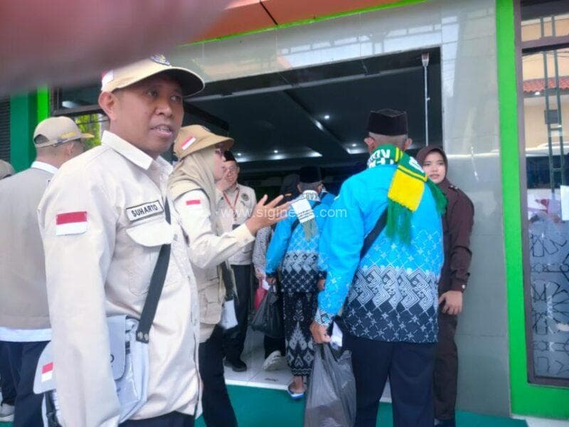 Petugas Haji Indonesia Tahun 2026 sedang mengarahkan calon jemaah haji memasuki hall Mina, Asrama Haji Embarkasi Surabaya (AHES). (foto : roi)