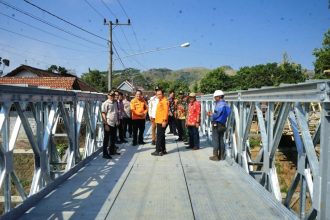 Kalaksa BPBD Jatim Gatot Soebroto bersama Pj Bupati Tulungagung Heru Suseno dan Kadis PU Bina Marga Jatim Edy Tambeng Widjaja, meninjau proyek jembatan bailey di Desa Kalidawir, Kabupaten Tulungagung,  Kamis (1/8/2024). (Foto : BPBD Jatim)