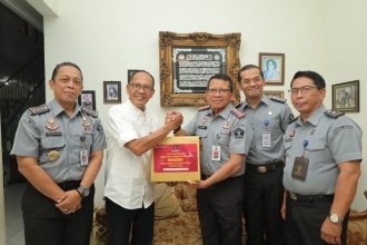 Kakanwil Kemenkumham Jatim Heni Yuwono memberikan bingkisan kenang-kenangan kepada purnawirawan pengayoman Imam Jauhari. (Foto : Humas Kemenkumham Jatim)