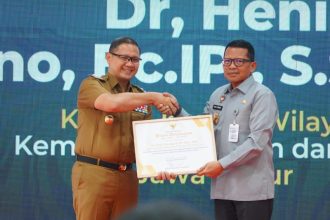 Pj Walikota Batu Aries Agung Paewai memberikan penghargaan kepada Kepala Kanwil Kemenkumham Jatim Heni Yuwono atas pelayanan Kekayaan Intelektual (KI). (Foto :Humas Kemenkumham Jatim)