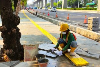 Pekerja memasang batu andesit pada pekerjaan konstruksi revitalisasi trotoar di kawasan Jalan HR Rasuna Said, Kuningan, Jakarta. (Foto : dok. SIG)
