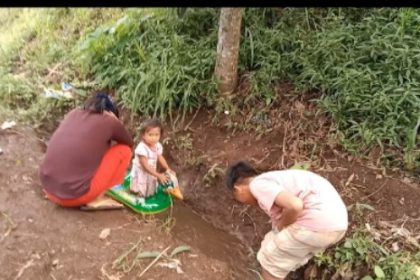 Anak-anak bermain aliran air yang diperkirakan dari proyek SPAM Singosari, Malang. (Foto : diharjo/siginews.com)