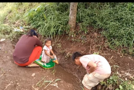 Anak-anak bermain aliran air yang diperkirakan dari proyek SPAM Singosari, Malang. (Foto : diharjo/siginews.com)