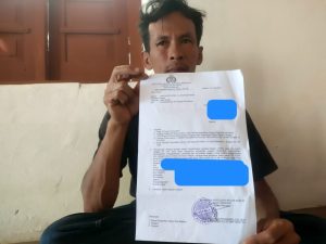 Nur Sahid, ayah dari pelajar MTs yang dilempari kotoran sapi oleh nenek tetangganya sendiri, menunjukkan surat perintah dimulai penyidikan dari Sat Reskrim Polres Madiun. (Foto : jero)
